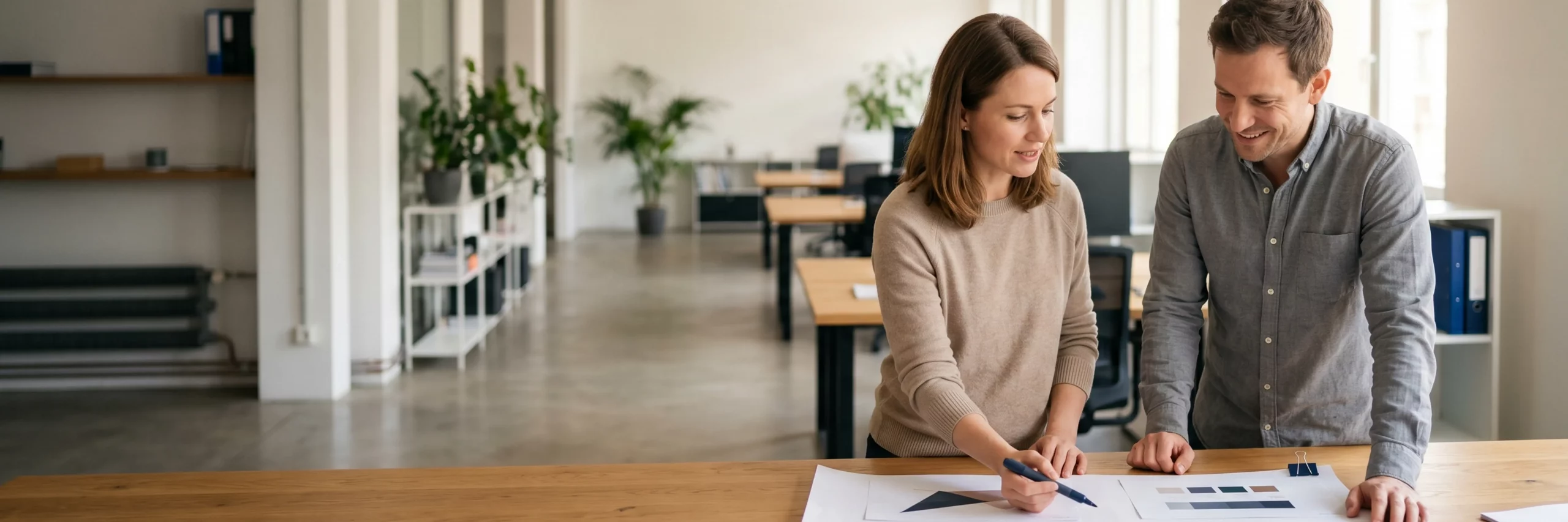 Zwei Experten prüfen gemeinsam strategische Markenkonzepte an einem Holztisch.