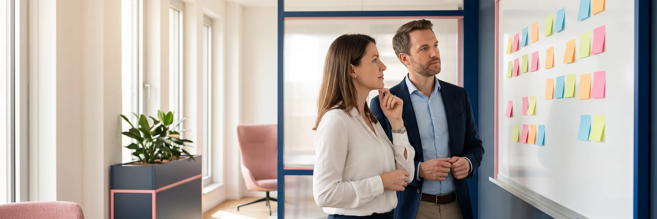 Zwei Strategen betrachten fokussiert ein Whiteboard bei der Planung einer neuen Marke